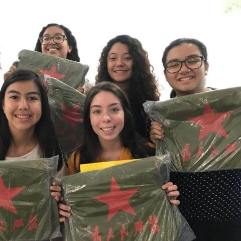 Four Mexican students holding up Chinese style bags