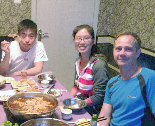 Student, homestay mother, and homestay brother enjoying dinner together at home